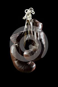 Old Boxing Gloves, hanging, on black Background