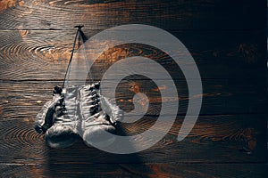 Old boxing gloves hanging on nail on wooden wall with copy space for tex