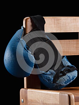 Old boxing gloves on nail black background