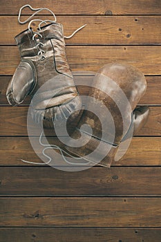 Old boxing gloves on the wooden surface with copy space for text. High resolution 3d render