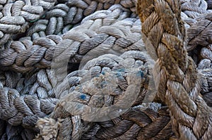 Old braided rope on the wooden deck of a sea boat, anchor mechanisms