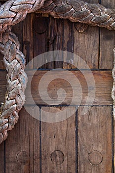 Old braided rope on the wooden deck of a sea boat, anchor mechanisms