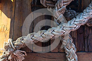 Old braided rope on the wooden deck of a sea boat, anchor mechanisms