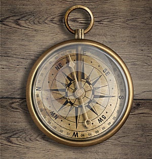 Old brass compass on wood table