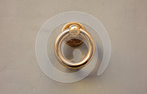 Old brass door knocker on a gray front door