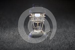 Old brass kerosene lamps,Antique brass lamp,Night camping lantern, on Gray grass background.soft focus.Monotone image form