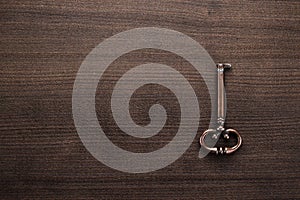 Old brass key on wooden table