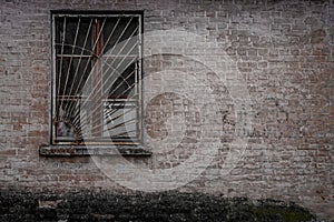 An old brick building with a barred window