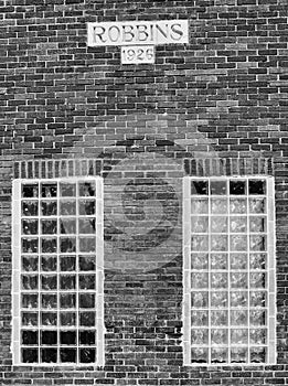 Old brick building facade. Block glass windows. Robbins 1926