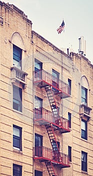 Old brick building with fire escape, color toning applied, New York City, USA