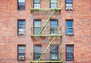 Old brick building with green fire escape, New York City, USA