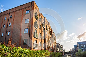 Old brick building renovated and converted in lofts along a canal at sunset