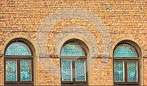 Old brick building, on a solid wall three windows