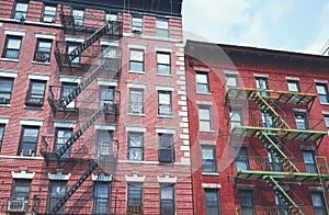 Old brick buildings with fire escapes, color toning applied, New York City, USA