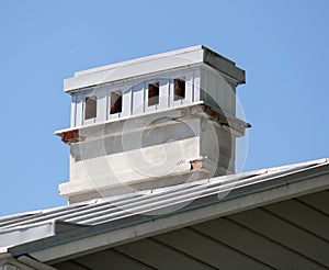 Old brick chimney on the roof of the house.