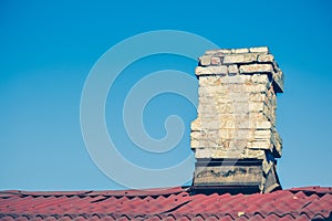 Old brick chimney on the roof for the smoke