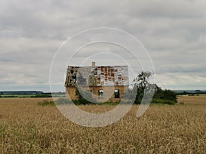 Old brick farmhouse in the countryside with storm clouds in the sky