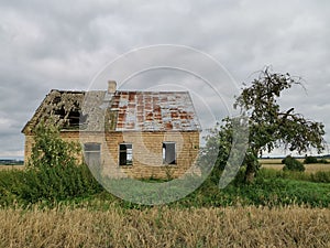 Old brick farmhouse in the countryside with storm clouds in the sky