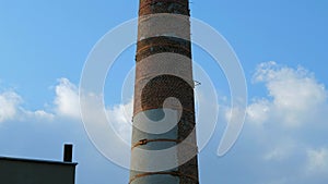 Old brick flue pipe on background blue sky