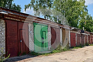 Old brick garages with metal gates. Garage cooperative for car storage