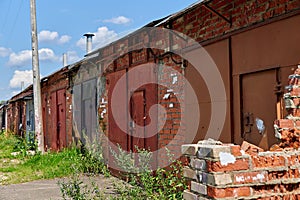 Old brick garages with metal gates. Garage cooperative for car storage