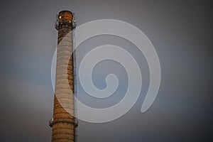 Old brick industrial chimney in the dark. A chimney of the Soviet era