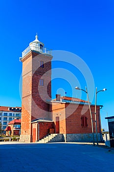 Old brick lighthouse at the Wieprza river mouth to the Baltic Sea in Darlowko, Poland