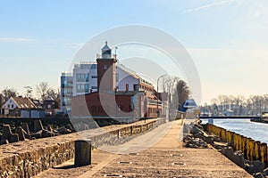 Old brick lighthouse at the Wieprza river mouth to the Baltic Sea in Darlowko, Poland