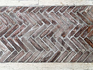 Old brick pavement in a herringbone style for background
