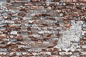 Old brick wall background with red grunge cement plastered rough texture for urban wallpaper backdrop
