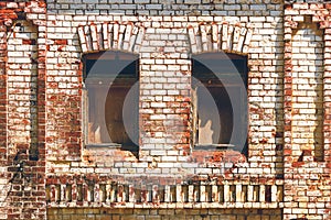 Old brick wall with boarded up windows. Old warehouse, retro city architecture. Brickwork of destroyed and weathered bricks with