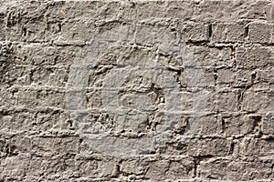 An old brick wall covered in gray paint