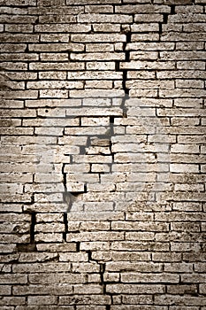 Old brick wall cracked and damaged - wall with diagonal crack