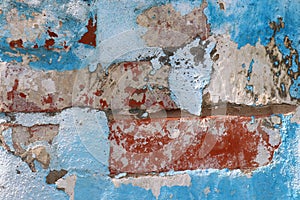 Old brick wall with peeling blue and red paint. Bright texture background