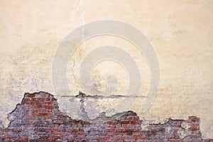 Old brick wall with peeling plaster, grunge background photo