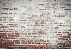 Old brick wall of red and white brick, covered with plaster in s