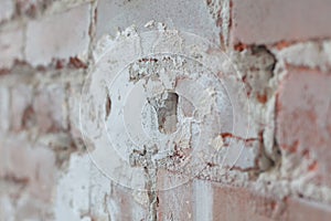 Old brick wall with white paint background texture close up. Side view, low depth of field.