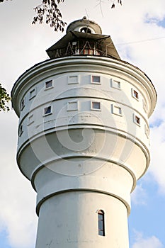 Old brick white ragged water tower on a sunny day