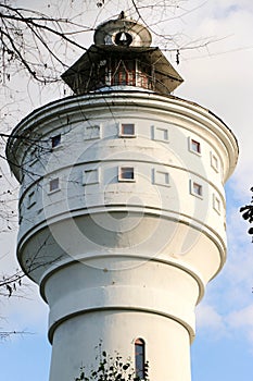 Old brick white ragged water tower on a sunny day