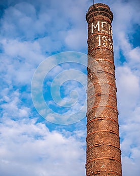 Old bricks factory chimney with bricks. blue sky background. color