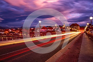 Old bridge across the Drava river at night, medieval city architecture and dramatic sky, Maribor, Slovenia