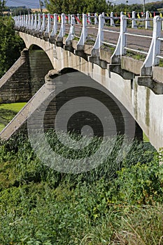 The old bridge over the river with blooming green water, the bridge was built in 1910 photo