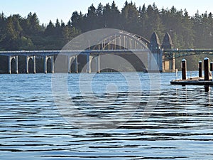 Old bridge over the Siuslaw river with dense shoreline trees