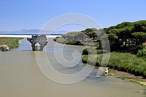 Old bridge on river leading to the sea in sunny Spain