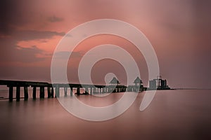 Old bridge in the sea on twilight time after sunset.