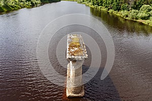 Old bridge support stands in river