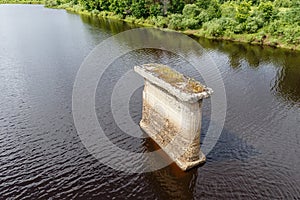 Old bridge support stands in river