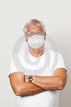 Old British men at risk by coronavirus. Old grey hair guy wearing a face mask for protection against coronavirus. Half body view o