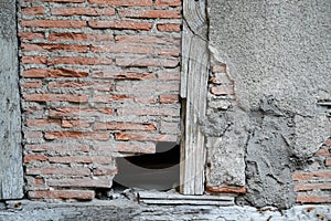 Old broken ancient brick wall home with a hole