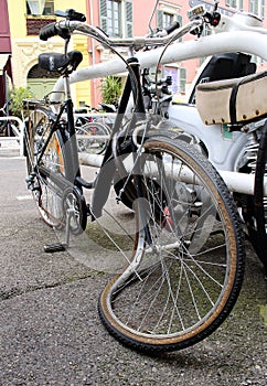 Old broken bicycle with a crooked wheel
